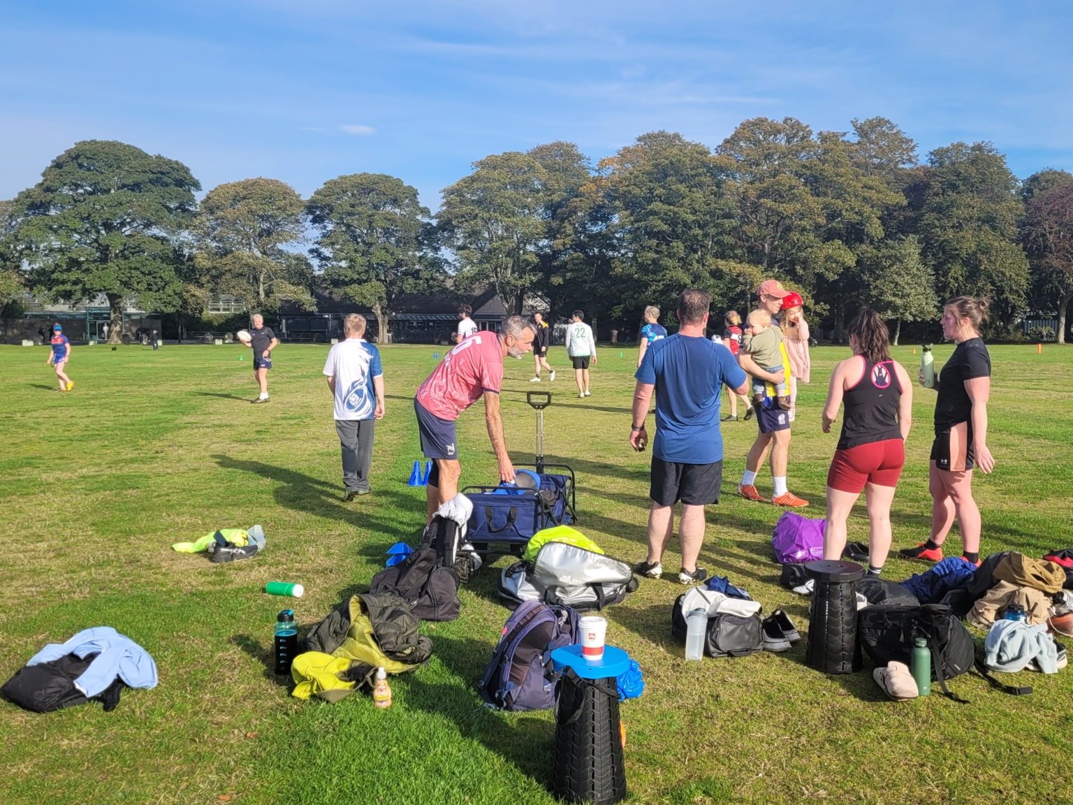 Players and volunteers gathering on a grass pitch before a Touch session