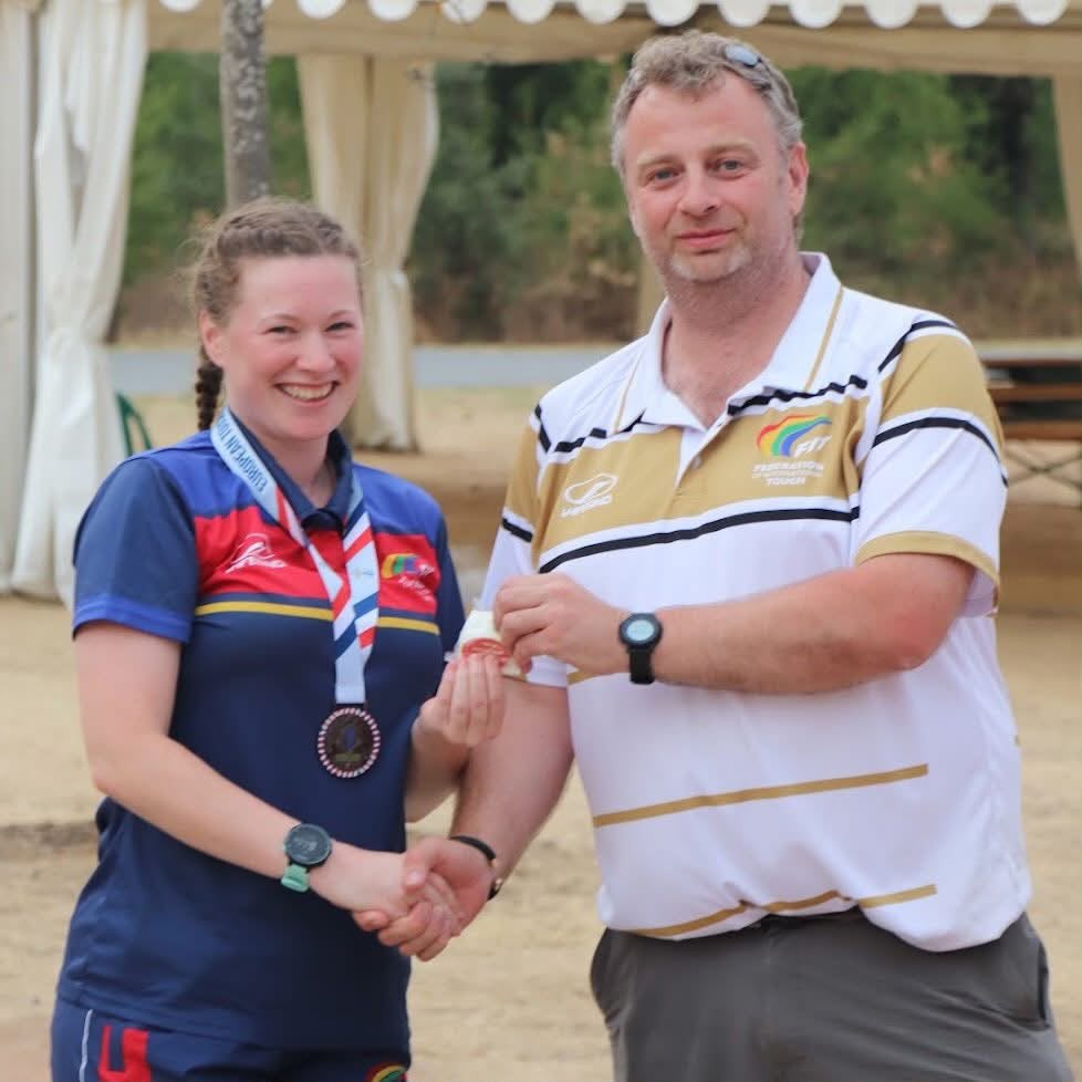 Clare Hammond, in Scotland kit, smiling and shaking hands with Mathew Sharkey as he hands her an award