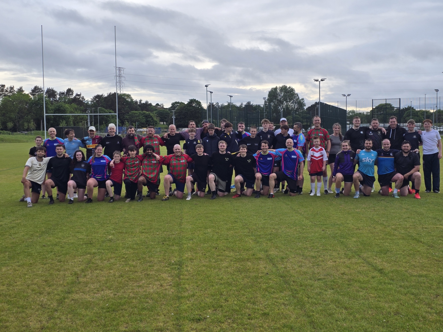 Dundee Touch players and coaches posing together for a group photo on the pitch